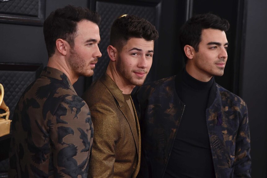 The Jonas brothers stand on the Grammys red carpet