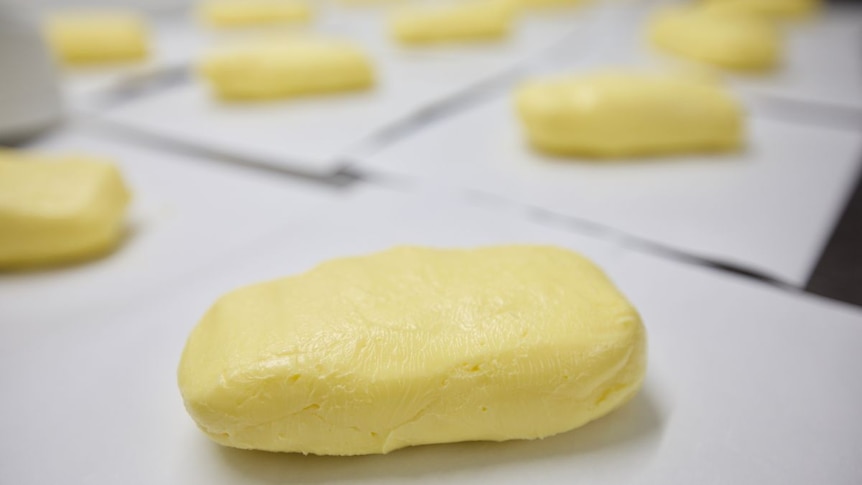 Sticks of butter waiting to be wrapped on a table.