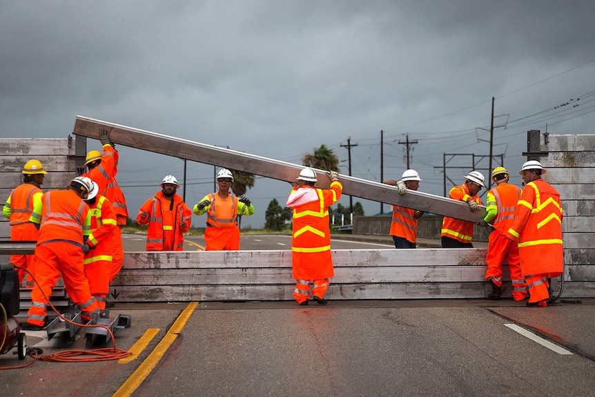 Crews install the final portion of a surge wall