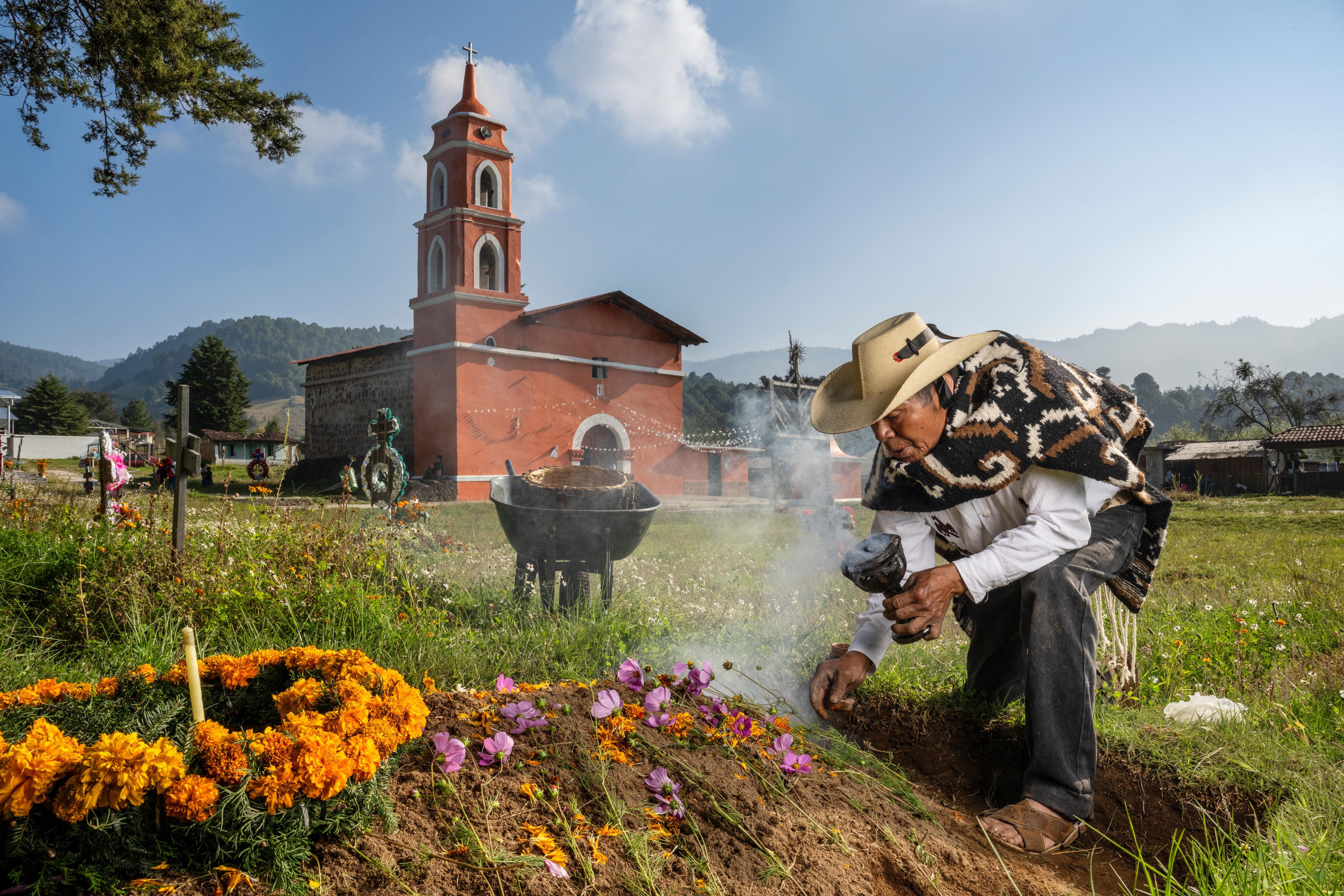 A man lays flowers on a grave