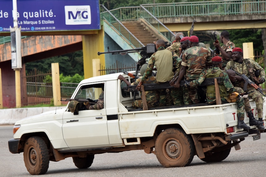 Members of the Armed Forces of Guinea drive through the central neighbourhood of Kaloum in Conakry