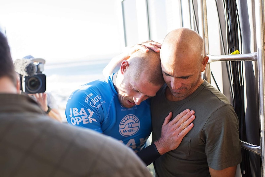 Mick Fanning embraced by Kelly Slater