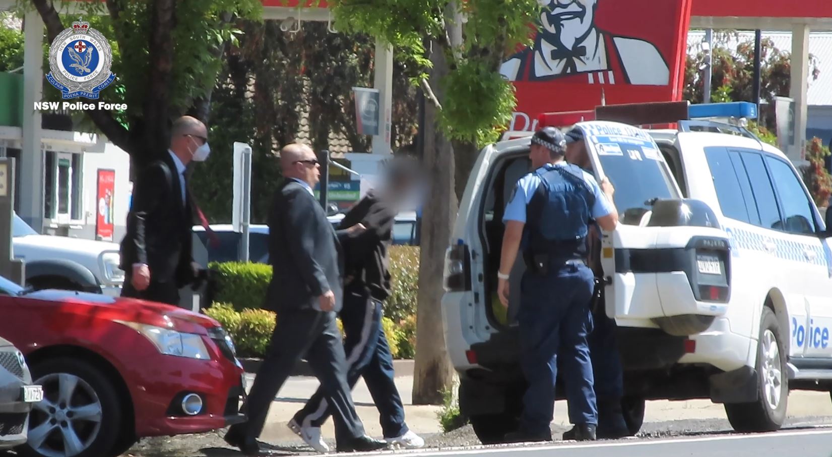 A man is arrested in a street of a country town.