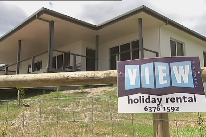 A holiday home with a sign out the front.