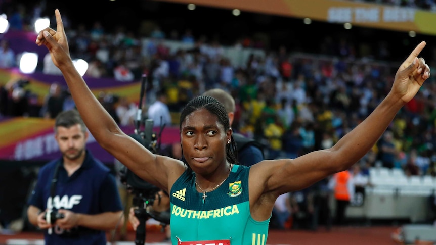 Caster Semenya raises both arms in the air after winning the 800 metres gold.