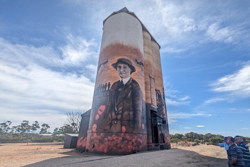 A portrait of Vivian Bullwinkel in nurse uniform surrounded by red poppies painted on a 15-metre tall silo.