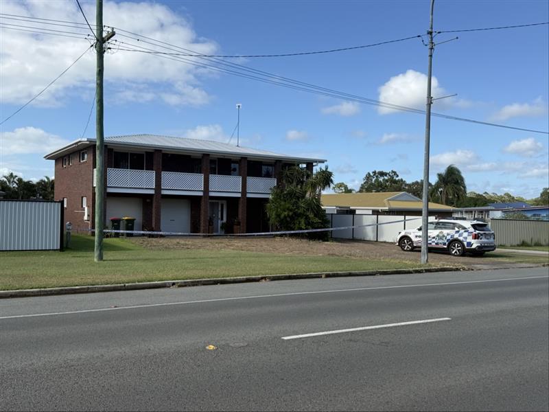 Un vehículo policial estaba estacionado frente a un edificio de apartamentos de ladrillo oscuro de dos pisos.
