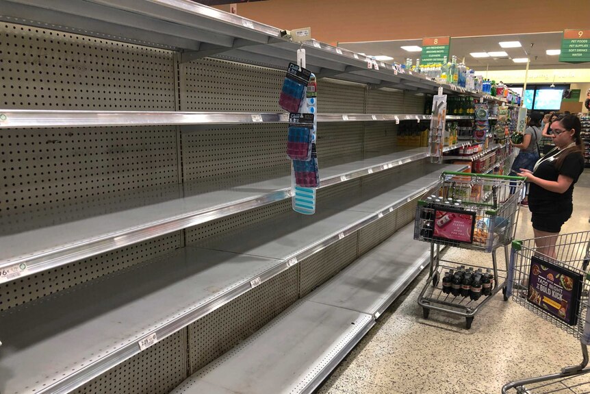 Shoppers mill around empty shelves amid hurricane preparations in Florida