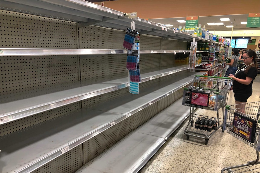 Shoppers mill around empty shelves amid hurricane preparations in Florida