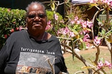 Kathy Watson in front of a plant.