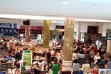 People wait in the evacuation centre at Stockland shopping centre in Cairns ahead of Cyclone Yasi