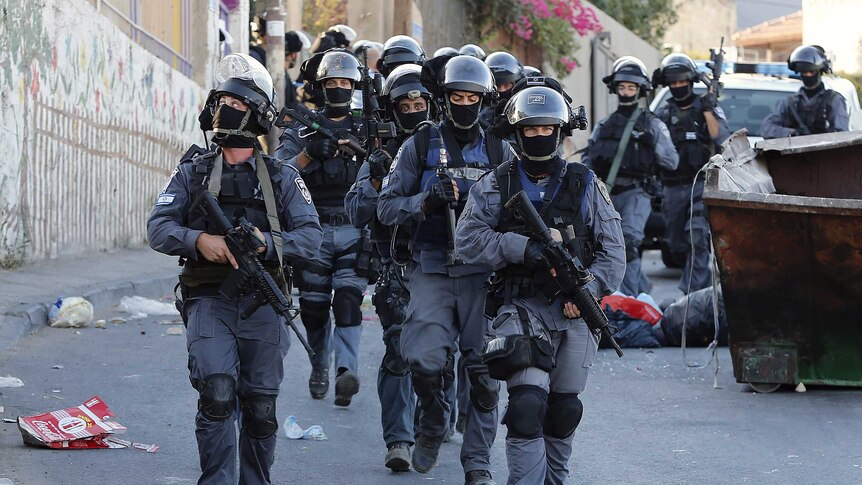 Israeli policemen patrol a street in Jerusalem's east