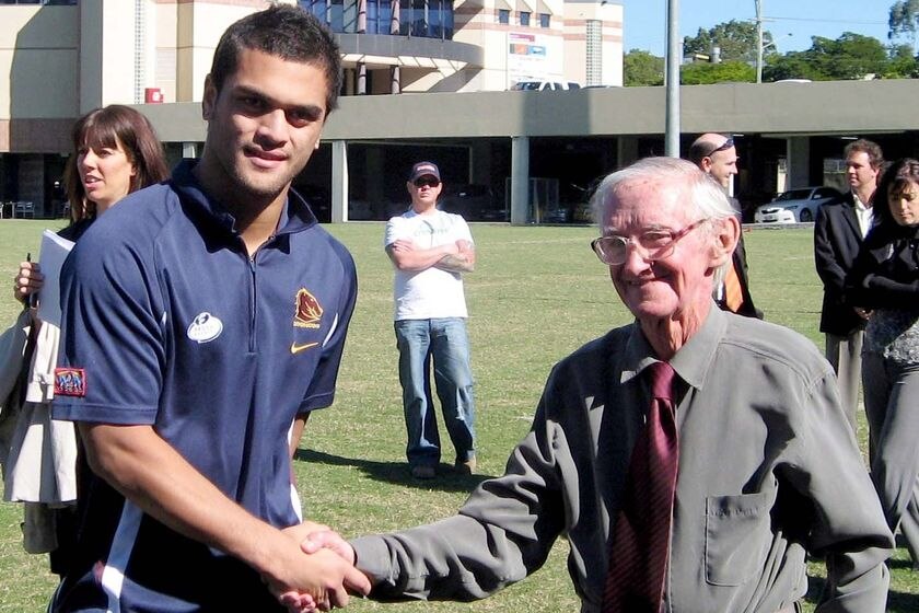 Karmichael Hunt shakes Cyril Connell's hand in front of a gymnasium building