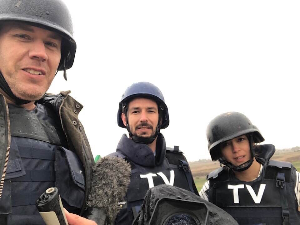 A woman and two men wearing bullet-proof vests and helmets.