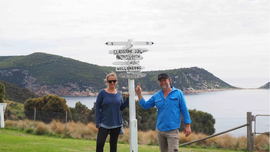 Rachel and Daniel Weeks in front of location signs.