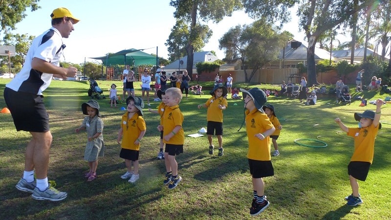 UWA Uni-Active program co-ordinator Ben Durant encourages students on a school oval to jump.