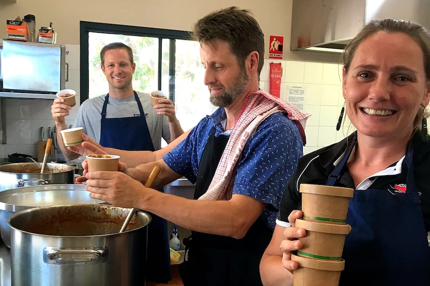 People cooking in large pots.