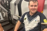 Man, sitting and smiling at camera, sitting on gym equipment 