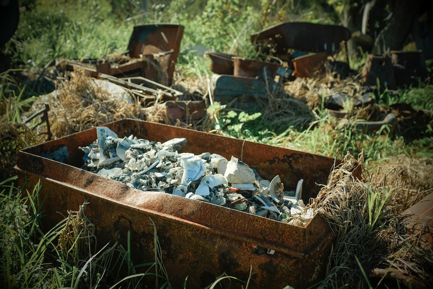A rusty chest of broken and burned objects