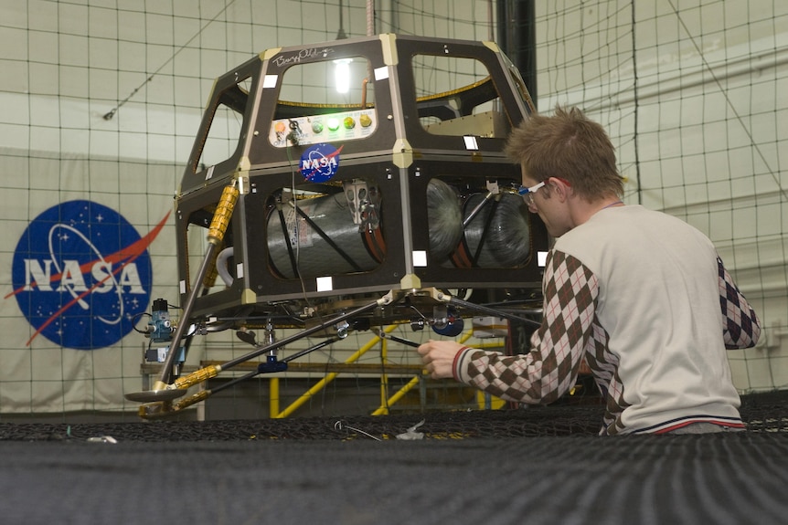 Man working on a robotic vehicle for NASA