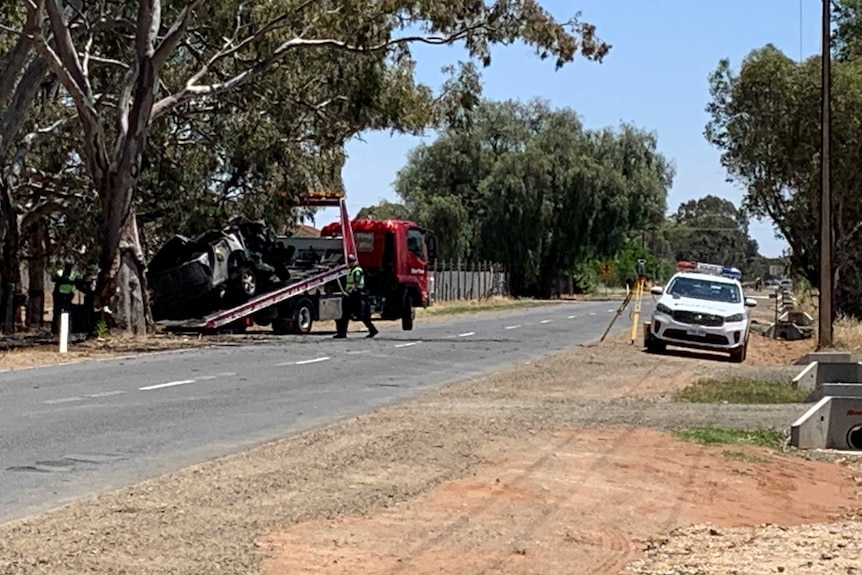 a crashed car being loaded onto a tow truck