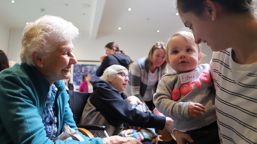 An older woman holding the hand of a child.