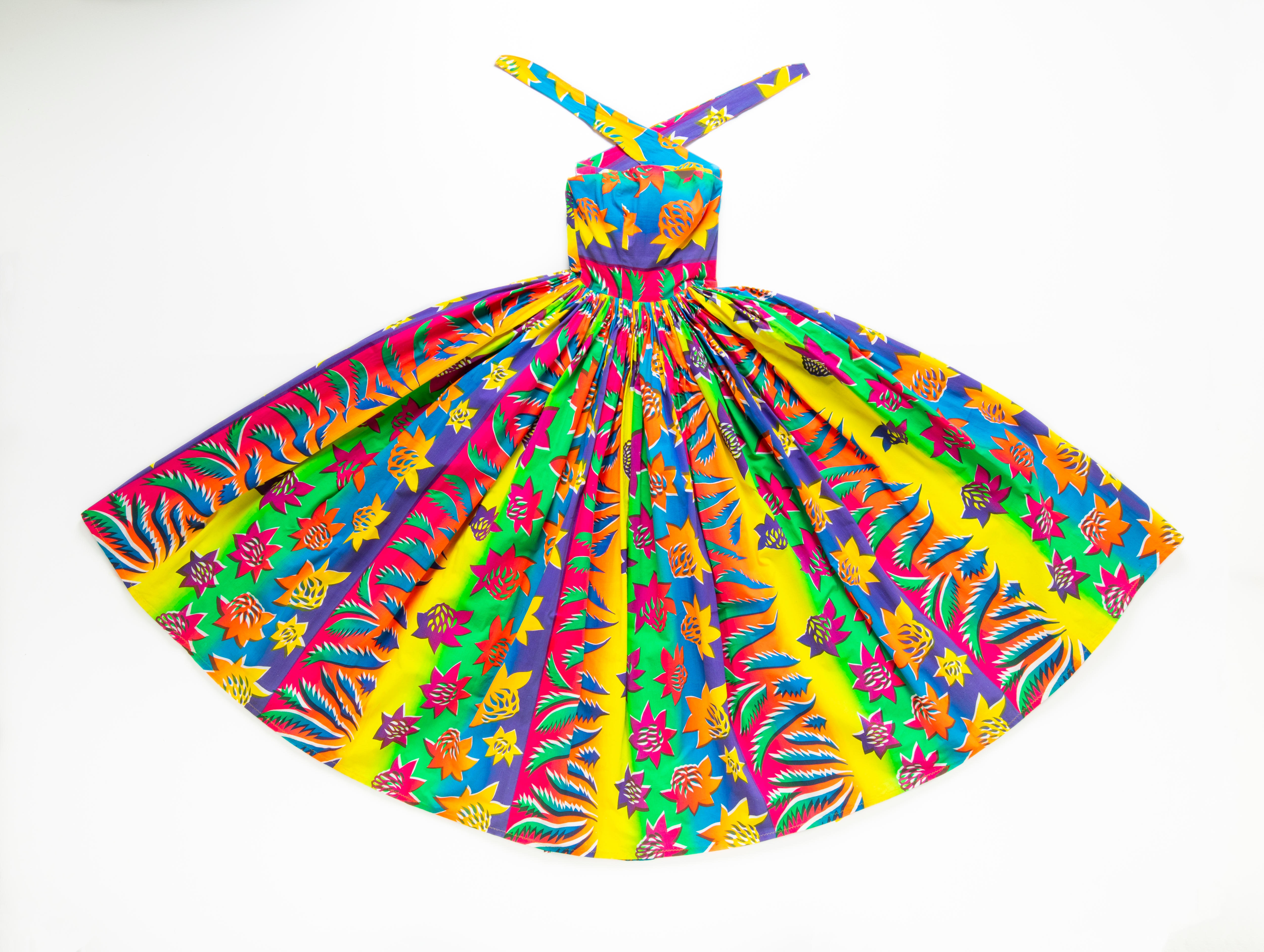 Colourful halter dress laid out on flat white surface.