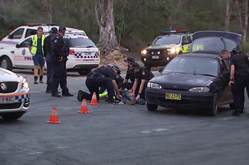 Police hold Ben Andrew Goring down on the road after pulling him out of his car in August 2016.