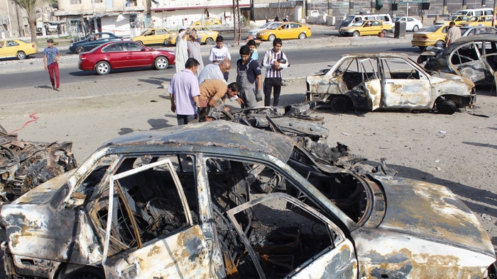 Residents gather at the scene of a car bombing in Baghdad on July 3.