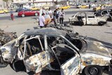 Residents gather at the scene of a car bombing in Baghdad on July 3.