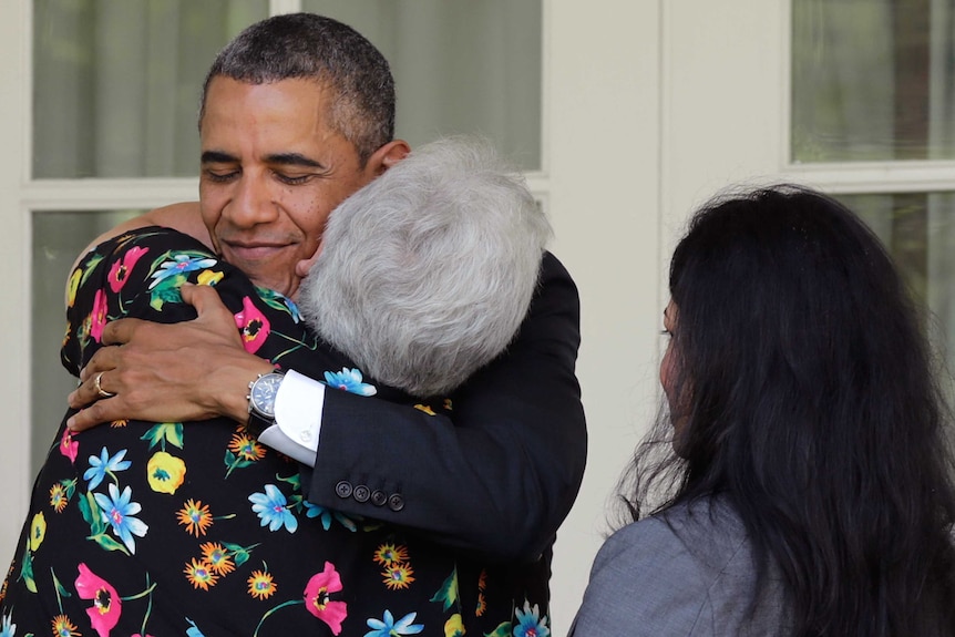 US President Barack Obama hugs an American woman in the Rose Garden of the White House.