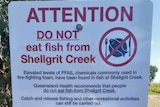 A sign reading ATTENTION DO NOT eat fish from Shellgrit Creek the bottom of the sign includes a map of PFAS contaminated areas