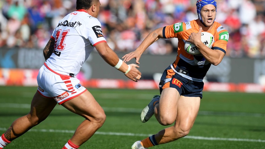 Kalyn Ponga runs past Tyson Frizell with the ball under his arm