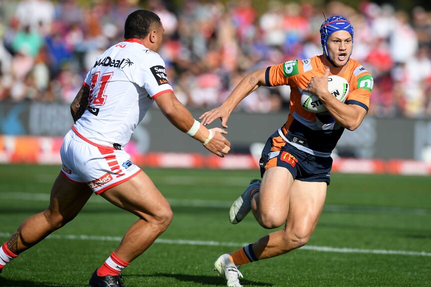 Kalyn Ponga runs past Tyson Frizell with the ball under his arm