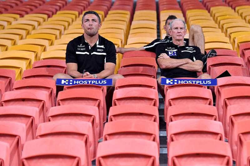 Two men sitting in an empty stadium.