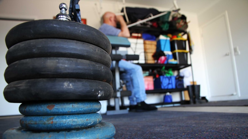 Child sexual abuse victim "Donald" sits on an exercise machine in his garage