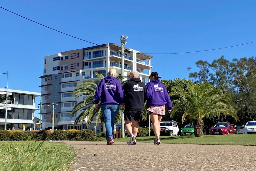 Three people wearing shirts saying Silver Fox Initiative walk away from camera