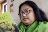 Sushmita Banerjee holds one of her Bengali language novels.