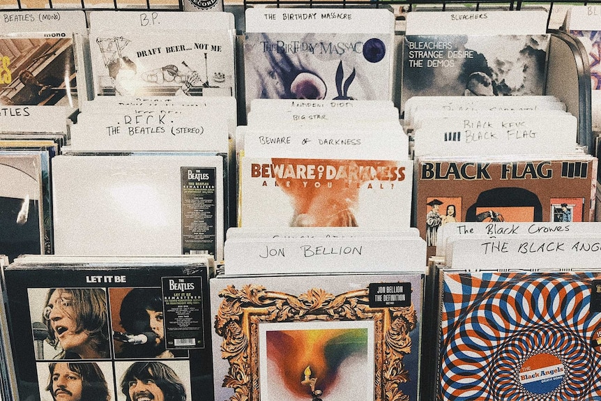 Photo of records in a rack to depict how to use music to heal after a break-up.