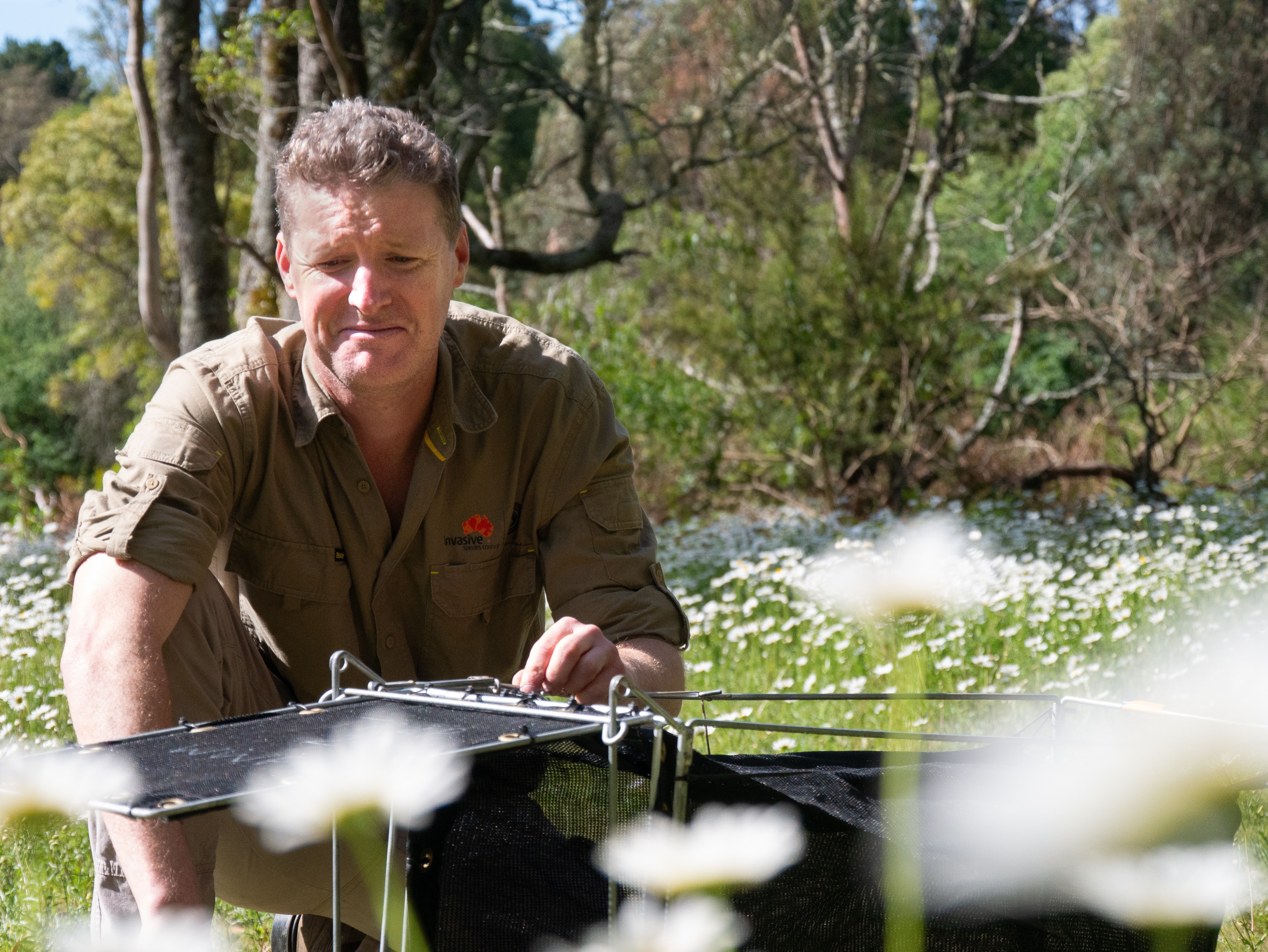 Man smiling at wildlife trap.