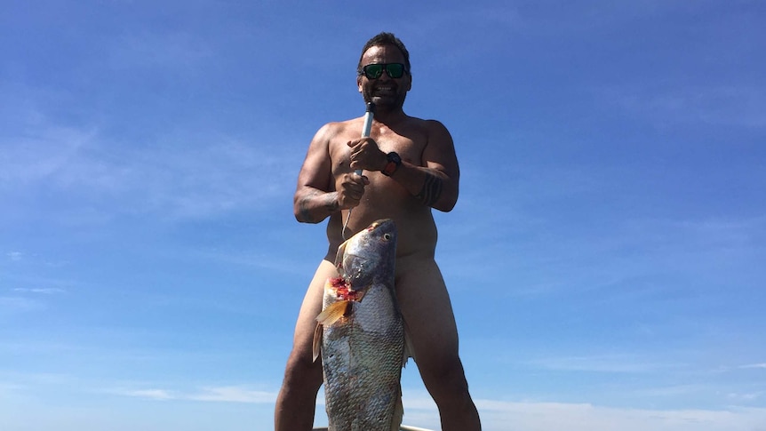 Unclad man with large Black Jewfish