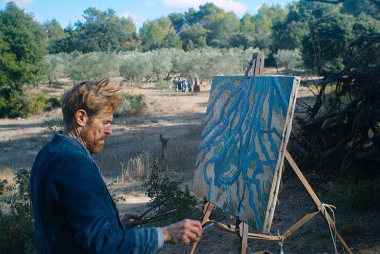 Colour still of Willem Dafoe painting in the countryside in 2018 film At Eternity's Gate.
