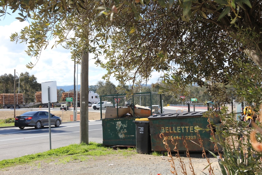 A skip bin emblazoned with the word 'Bellettes' on the side of a road in Tumut.