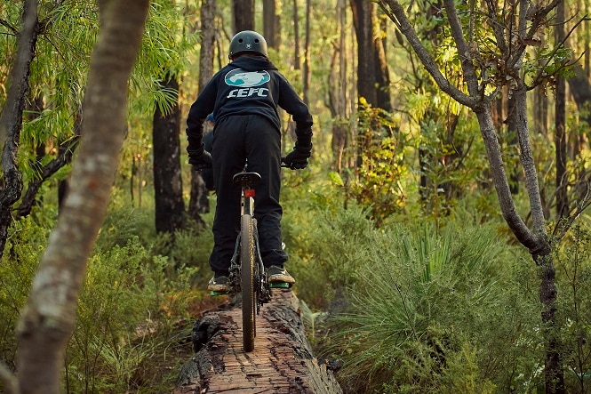 A man riding on a mountain bike through the forest