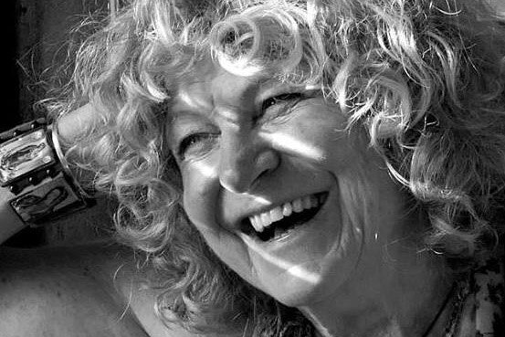 A black white image of a woman with curly hair smiling