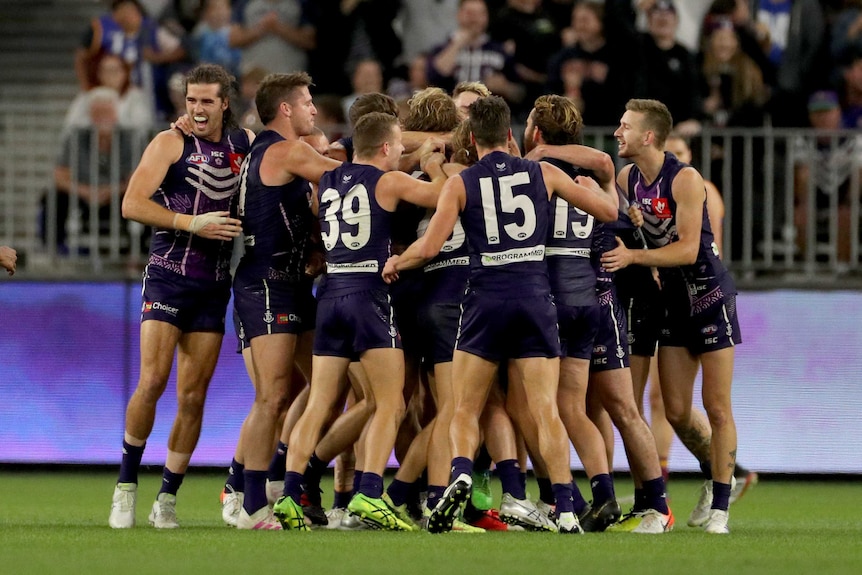 Dockers players group in a huddle as they celebrate beating the Lions.