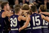 Dockers players group in a huddle as they celebrate beating the Lions.