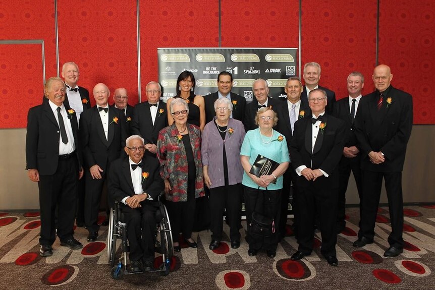 Group photo of older athletes and their partners at the Australian Basketball Hall of Fame. 