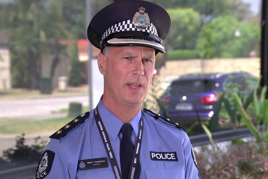 A police officer in uniform addresses media