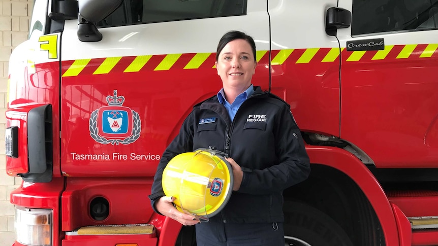 Tasmania Fire Service's first female Station Officer, Sandra Onn, stands in front of a fire truck.